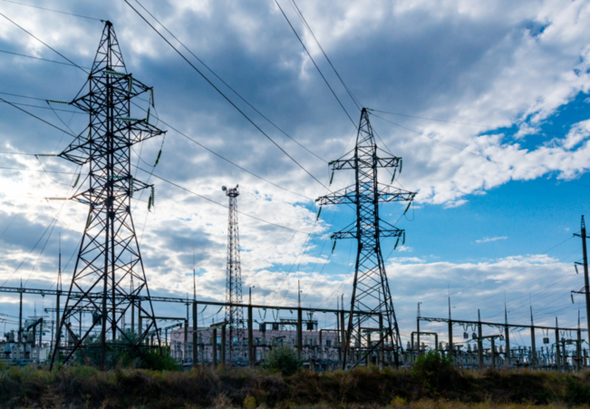 High-voltage lines on steel structures with wires against the background of the sky with clouds