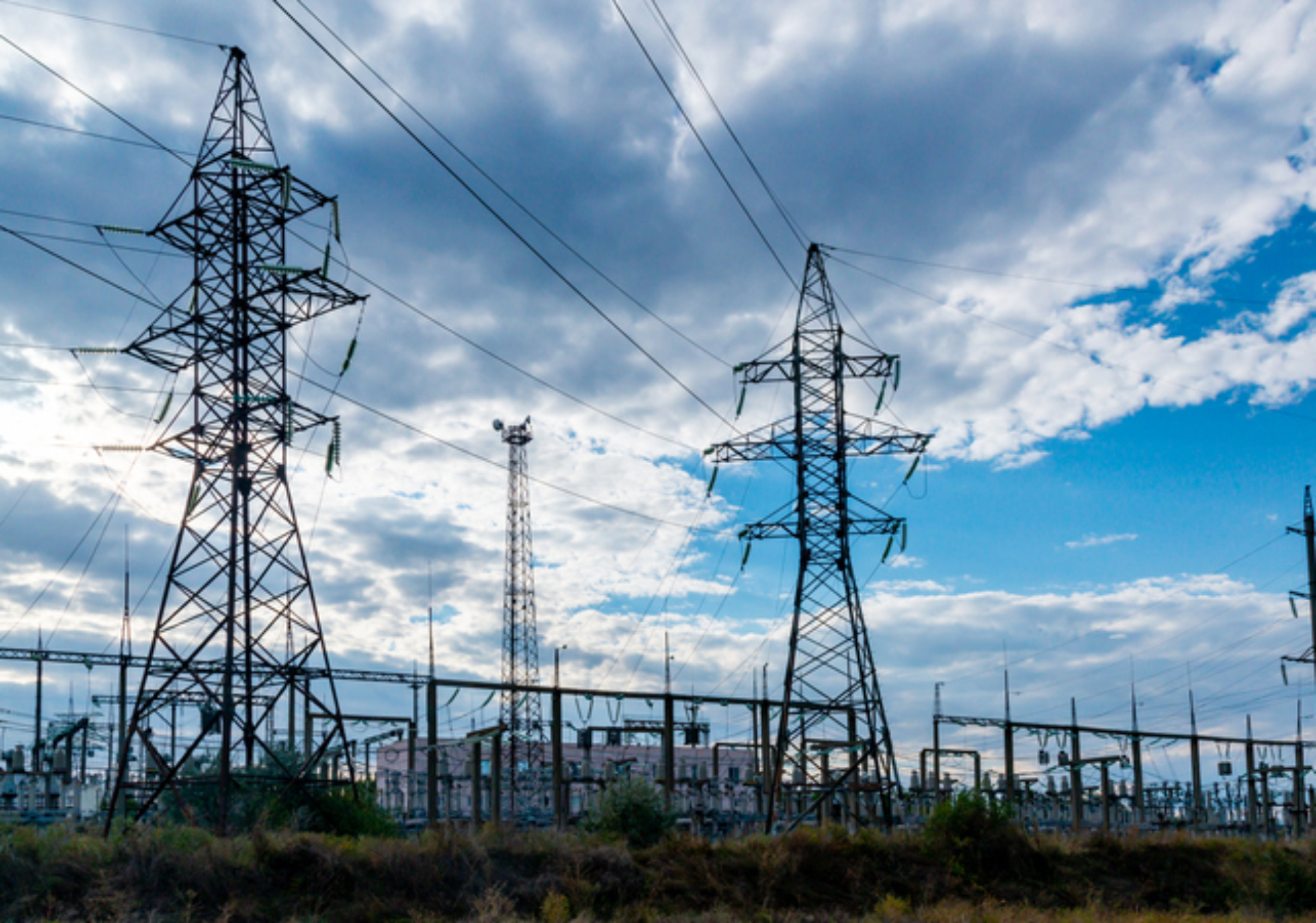 High-voltage lines on steel structures with wires against the background of the sky with clouds